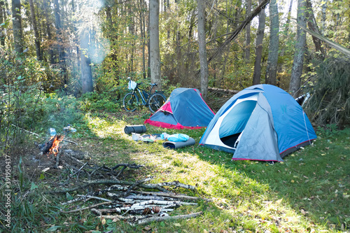 Hiking tents, bonfire and bicycles in forest