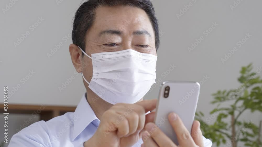 スマホを操作する中高年男性 スマホを操作する中高年男性