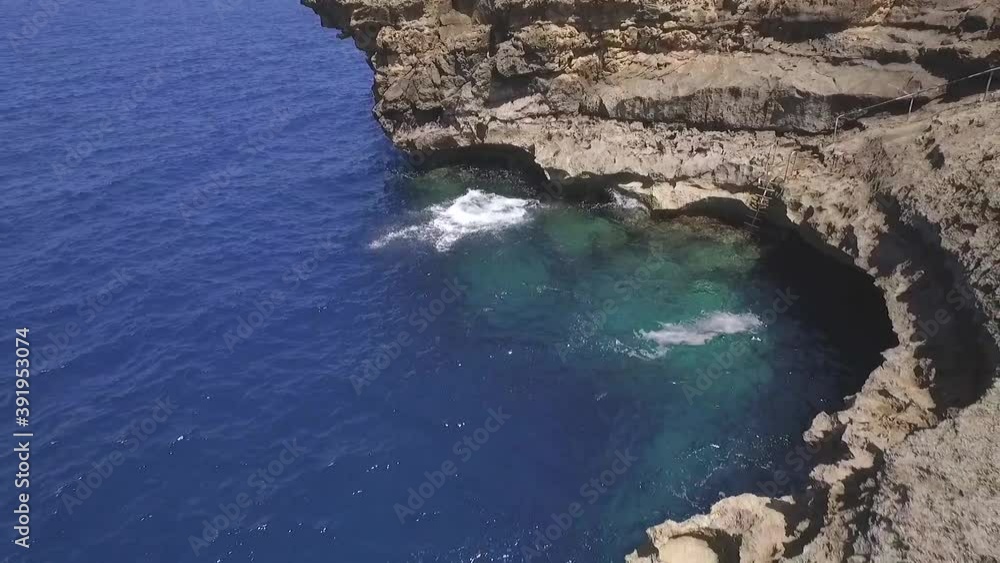 AERIAL: Guy is jumping in the sea in Malta AERIAL: Guy is jumping in the sea in Malta