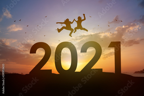 Silhouette Happy man and woman jump over 2021 year with sunset background. Team success, New year new Business vision concept.