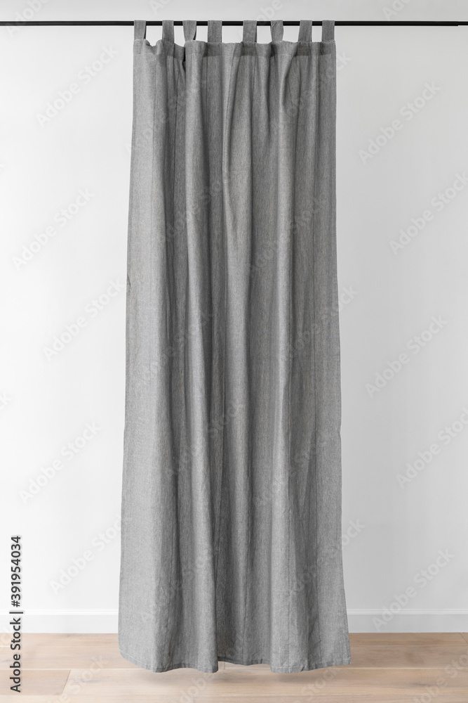 Gray drapery hanging from a curtain rod Gray drapery hanging from a curtain rod