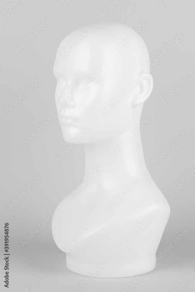 White mannequin head in profile on a gray background White mannequin head in profile on a gray background