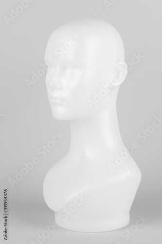 White mannequin head in profile on a gray background