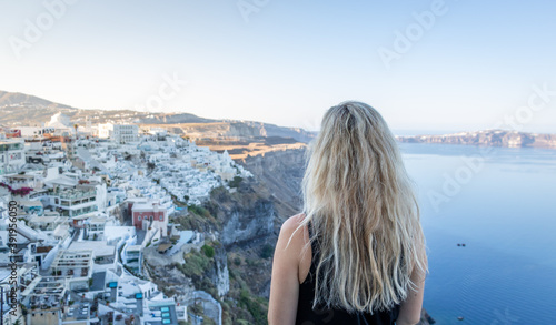 Fototapeta Naklejka Na Ścianę i Meble -  A woman admiring a beautiful view of Santorini