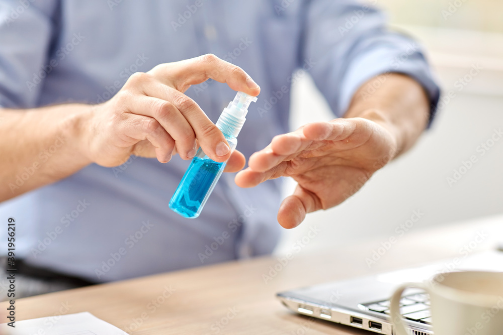 business, health care and pandemic concept - close up of middle-aged man with laptop computer using antibacterial hand sanitizer at home office business, health care and pandemic concept - close up of middle-aged man with laptop computer using antibacterial hand sanitizer at home office