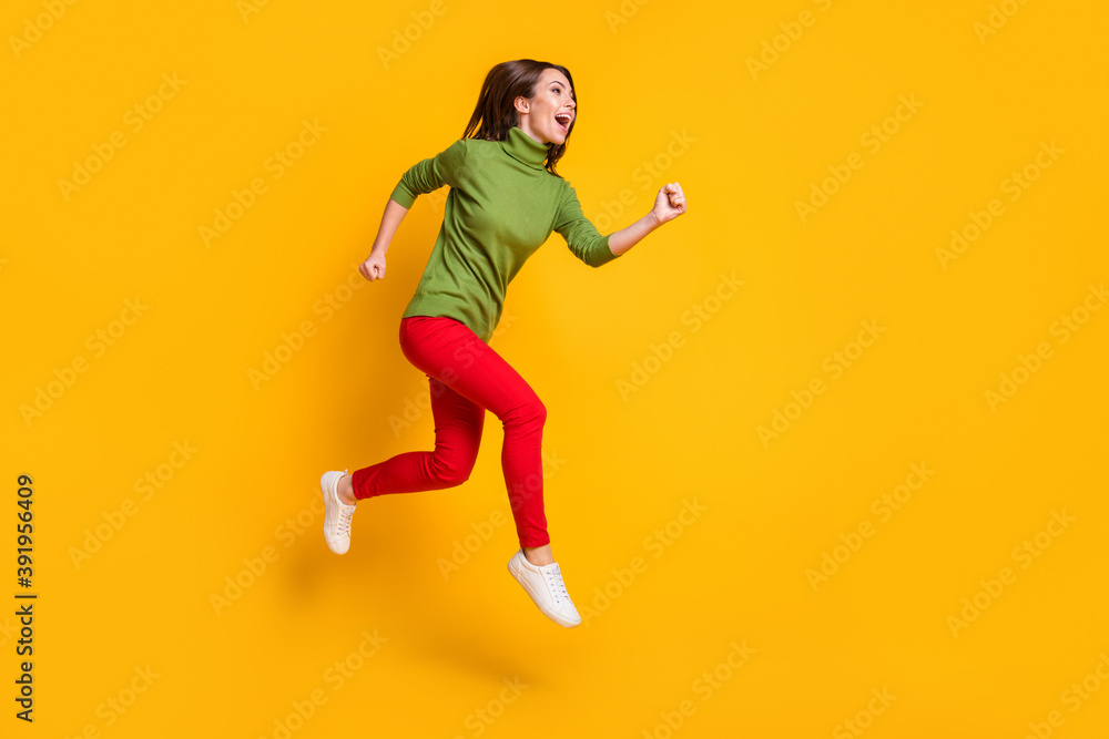 Lady jump up rushing excited wear casual green pullover shoes red trousers isolated yellow color background