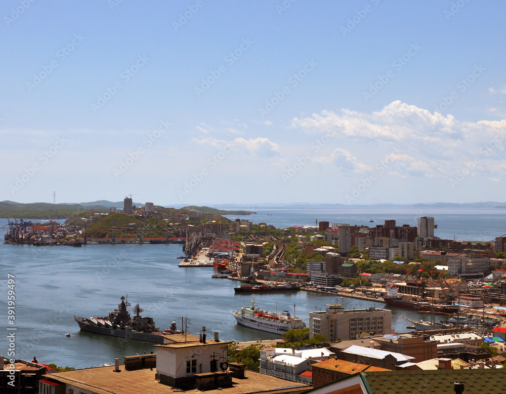 Panoramic top view of Vladivostok city: residential buildings, harbour, ships, Golden bay of Sea of Japan and hills in the background. Primorsky Krai, Russia.