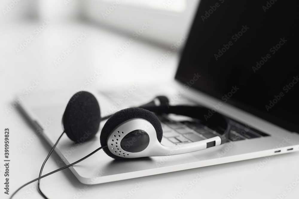 Workplace, laptop computer with headphones headset. Business, technology, working from home, conference, studying, e-learning, meeting online, chat, call center concept Workplace, laptop computer with headphones headset. Business, technology, working from home, conference, studying, e-learning, meeting online, chat, call center concept