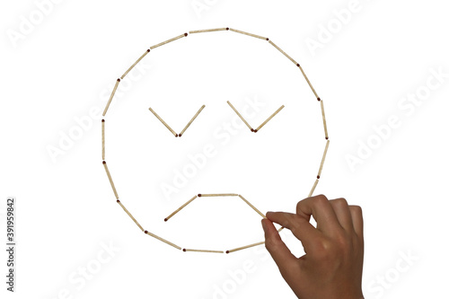 I make a picture of matches in the form of a sad face with closed eyes photo