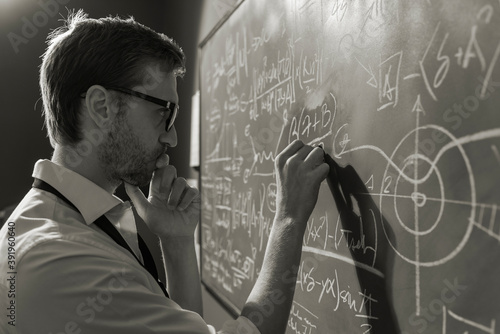 Fényképezés Young smart mathematician drawing on the chalkboard
