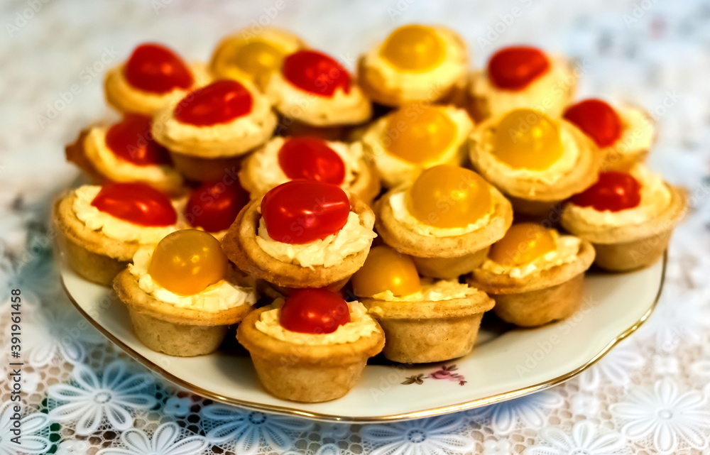Tartlets with salad and tomatoes on a plate close-up against a white tablecloth