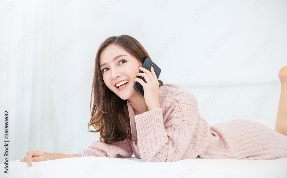 Asian woman with sweater attractive smile use tablet smartphone, Portrait young beauty sexy girl relax in bedroom. Technology people connection digital online marketing e-commerce winter concept Asian woman with sweater attractive smile use tablet smartphone, Portrait young beauty sexy girl relax in bedroom. Technology people connection digital online marketing e-commerce winter concept
