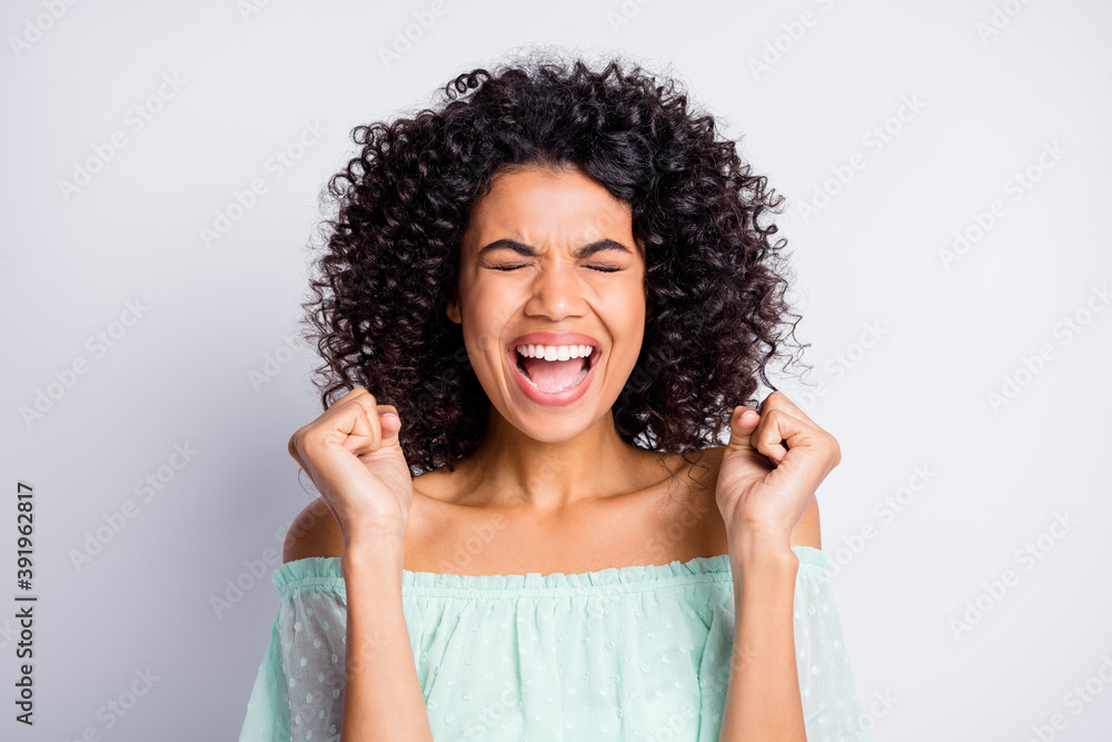 Portrait of young afro beautiful charming happy excited crazy girl woman smiling closed eyes isolated on grey color background Portrait of young afro beautiful charming happy excited crazy girl woman smiling closed eyes isolated on grey color background
