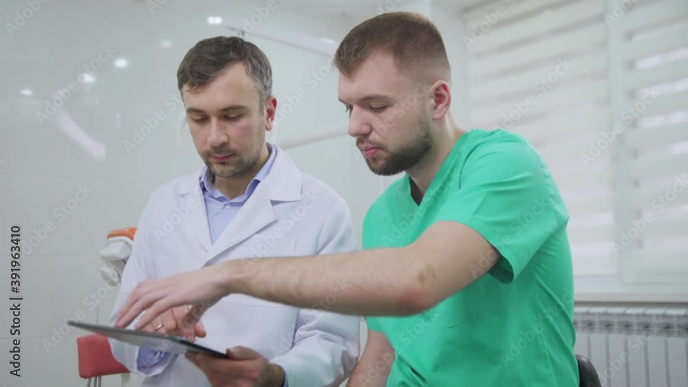 Two doctors discussing a pacient case at dental cabinet Two doctors discussing a pacient case at dental cabinet
