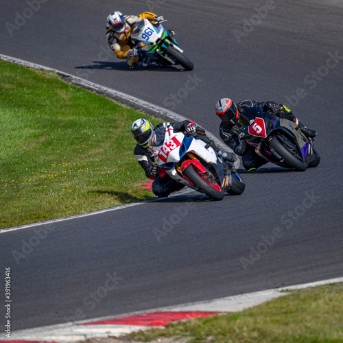 A shot of several racing bikes cornering on a track.