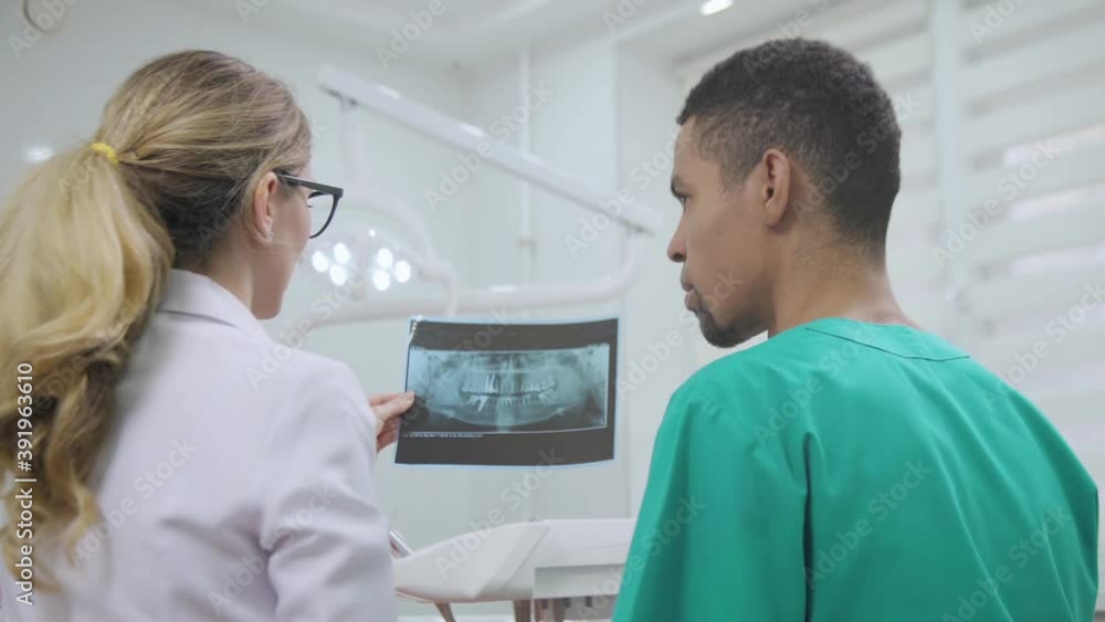 Doctor and nurse discussing medical case at the dental cabinet Doctor and nurse discussing medical case at the dental cabinet