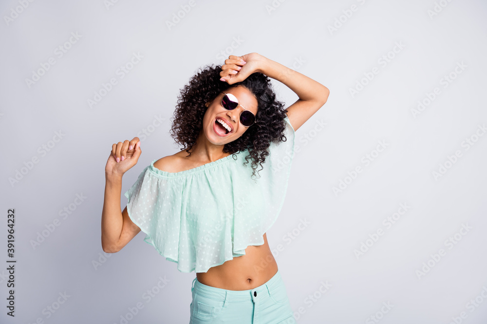Photo portrait of funny brunette girl curly hair wearing sunglass dancing at party laughing isolated on grey color background Photo portrait of funny brunette girl curly hair wearing sunglass dancing at party laughing isolated on grey color background
