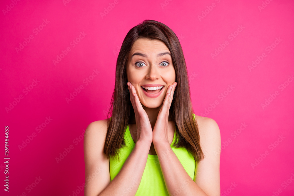 Portrait of surprised pretty brunette long straight hair young lady wear green top isolated on bright pink background Portrait of surprised pretty brunette long straight hair young lady wear green top isolated on bright pink background