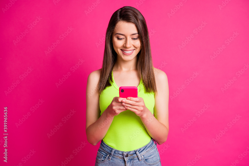 Photo of charming girl hold telephone look screen wear green singlet isolated vibrant pink color background Photo of charming girl hold telephone look screen wear green singlet isolated vibrant pink color background