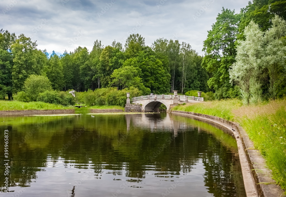 Summer landscape in a city Park with trees, stone bridge and sky with clouds Summer landscape in a city Park with trees, stone bridge and sky with clouds