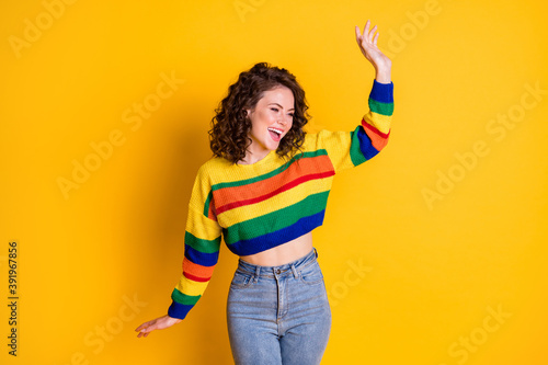 Photo of careless charming lady raise hand dance wear striped cropped sweater jeans isolated yellow color background