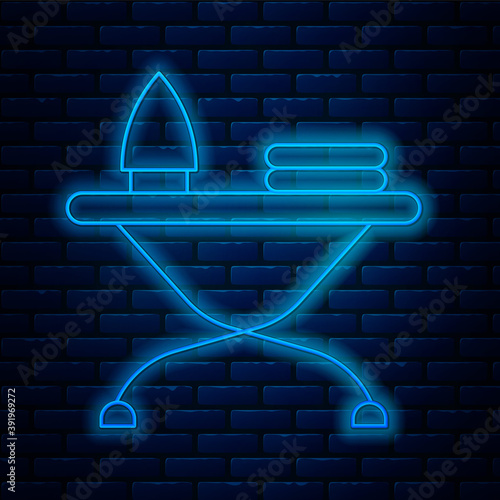 Glowing neon line Electric iron and ironing board icon isolated on brick wall background. Steam iron. Vector.