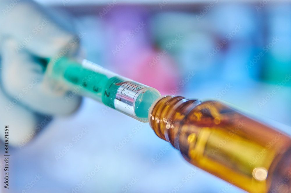 Close up of a syringe with vaccine. Close up of a flask with vaccine
