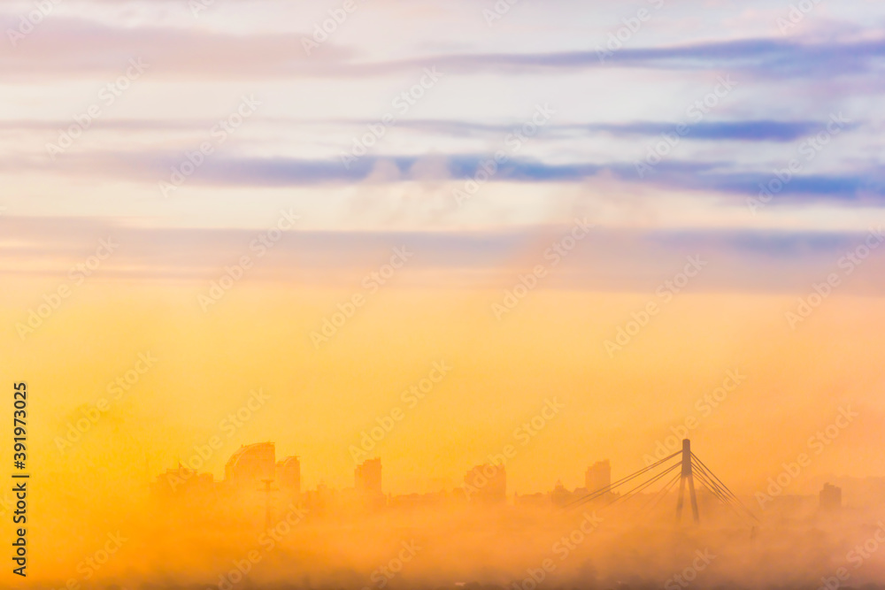 City bridge in fog with sunset clouds on sky