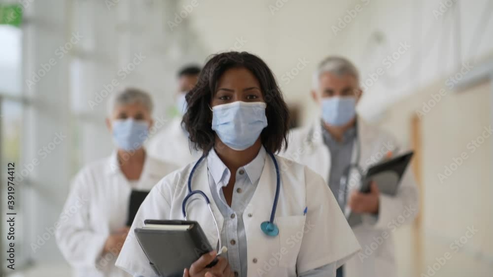 Group of doctors standing in hospital corridor with face mask Group of doctors standing in hospital corridor with face mask