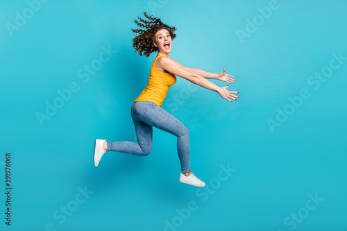 Fototapeta Naklejka Na Ścianę i Meble -  Full length photo of crazy lady jump high rush season shopper wear casual clothes isolated blue color background