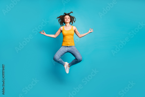 Fototapeta Naklejka Na Ścianę i Meble -  Full length photo of calm tranquil lady jump high practicing morning yoga isolated blue color background