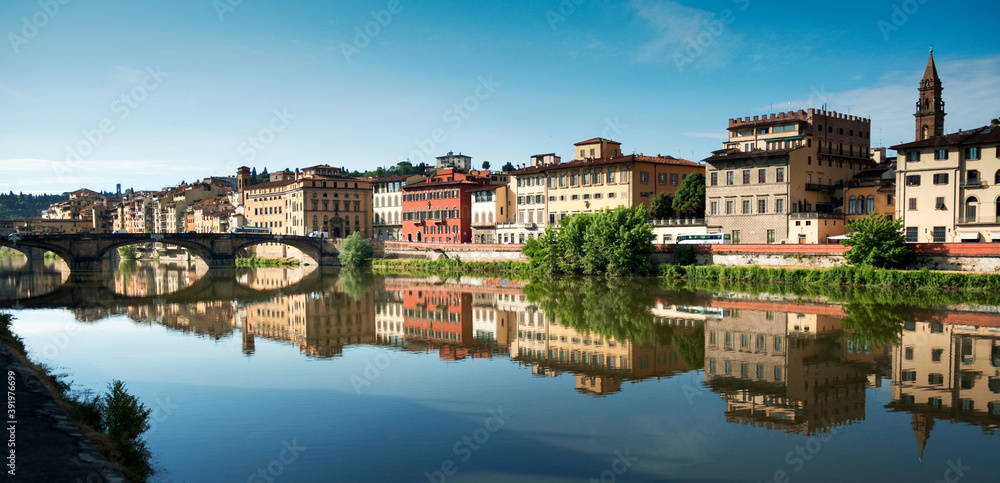Panoramic view of the city of Florence on the banks of the Arno river with the reflection of the colored houses in the water.