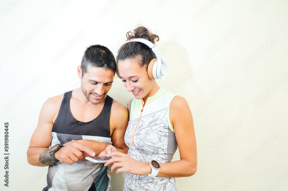 young couple of runners looking at the mobile in during a break young couple of runners looking at the mobile in during a break