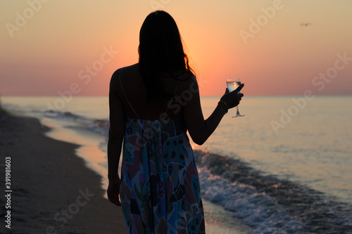 madame at sea stands with a glass of wine