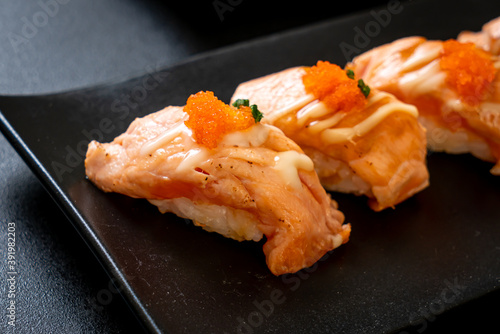 grilled salmon sushi on black plate