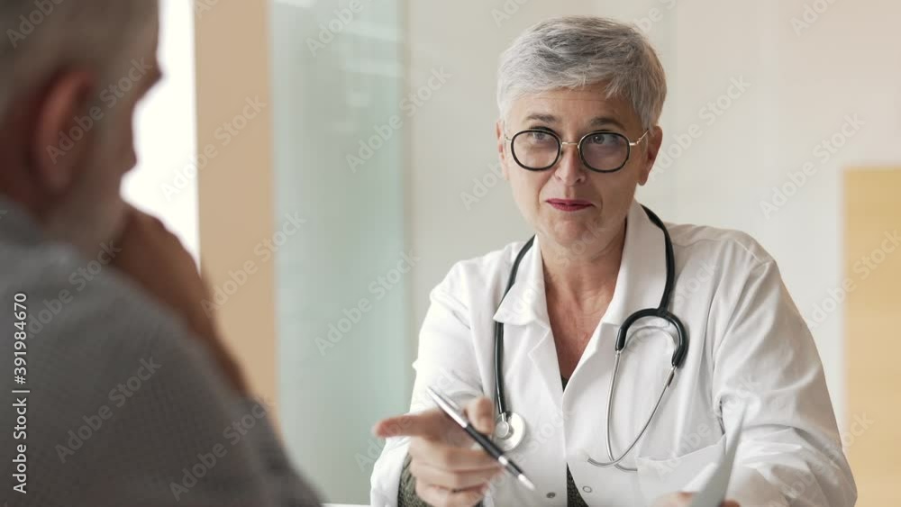 Mature woman doctor in medical consultation with patient Mature woman doctor in medical consultation with patient