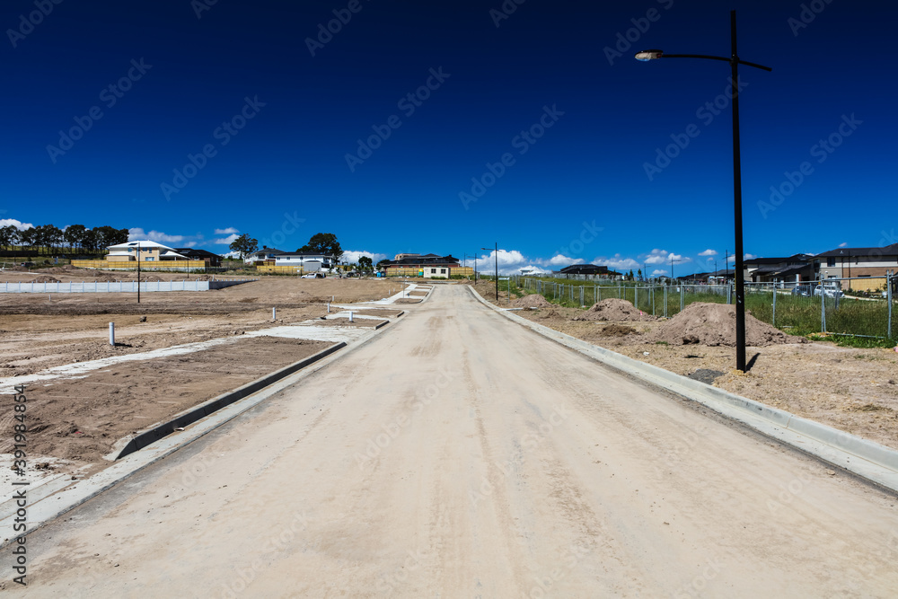 On the outskirts of Melbourne Australia, a new estate is being built, heavy machinery has terraformed the hillside, roads have been laid, gutters and driveways ready before houses can be built.