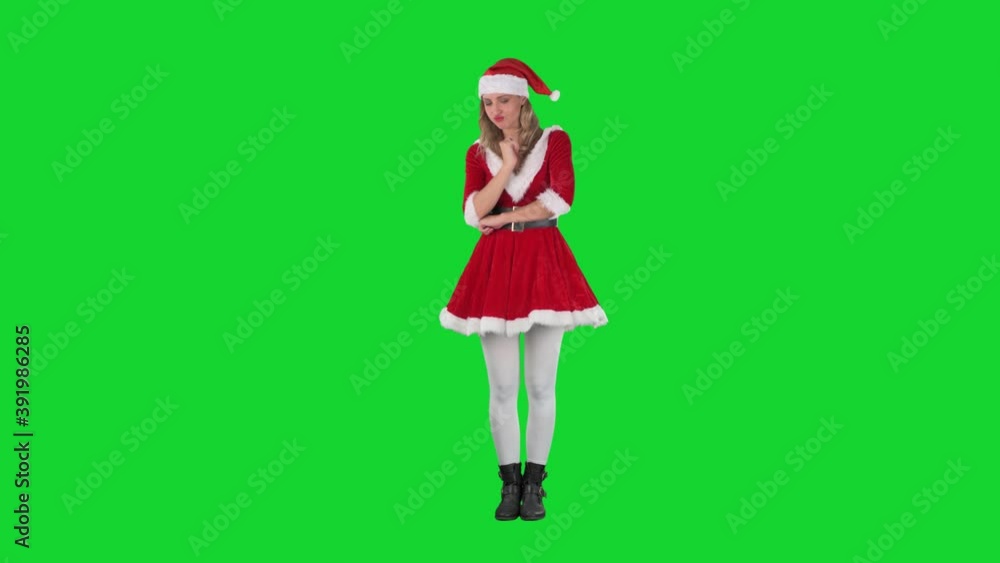 Puzzled Santa girl looking down searching something lost on the ground. Full body on chroma key green screen. Puzzled Santa girl looking down searching something lost on the ground. Full body on chroma key green screen.