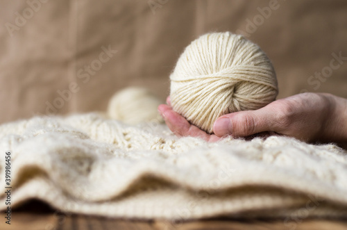 light warm openwork knitted blanket and balls of yarn. knitted background. home comfort. yarn in hand. Hobbies at home