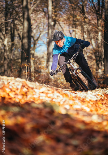 Mountain biker riding in autumnal forest in Hampshire, England 
