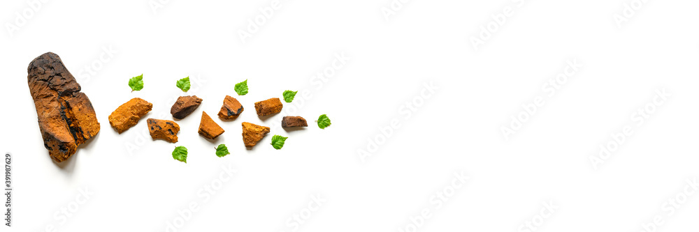 peeled piece of birch chaga mushroom and crushed chaga fungus pieces for tea brewing isolated on a white background. banner. space for text peeled piece of birch chaga mushroom and crushed chaga fungus pieces for tea brewing isolated on a white background. banner. space for text