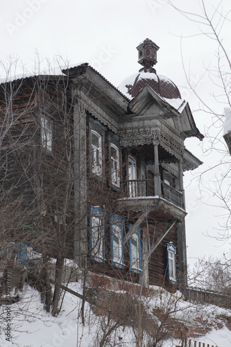 Vintage wooden house with ornamental carved windows, frames, balcony on Kuznechny Vzvoz, 6, Tomsk city, Russia. Art nouveau, russian folk style in architecture. Tomsk landmark, monument, sightseeing photo