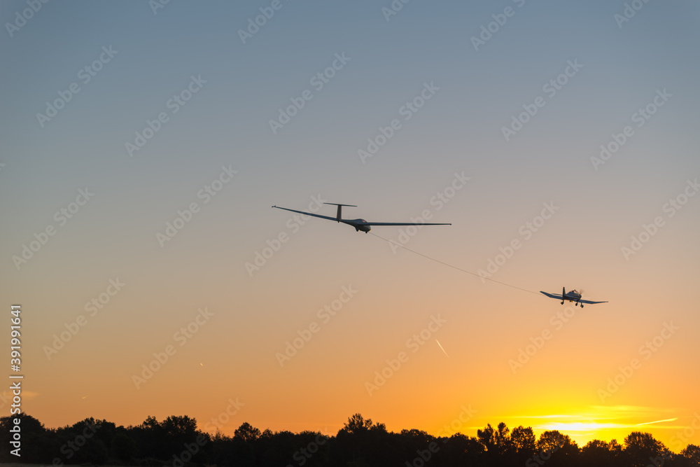 Remorquage d'un planeur avec un avion au levé du soleil Remorquage d'un planeur avec un avion au levé du soleil