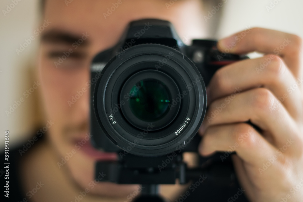 close-up of a boy taking a picture with a professional camera. Concept of photography, hobby, business.
