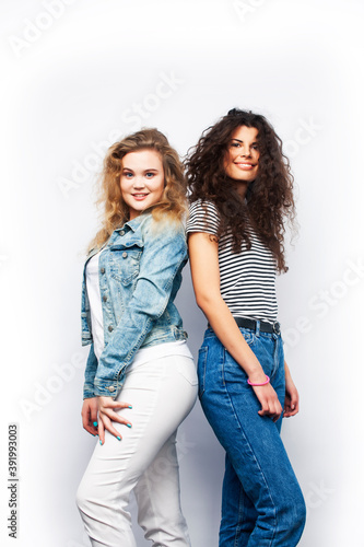 young pretty teenage girls friends with blond and brunette curly hairs posing cheerful isolated on white background, lifestyle people concept