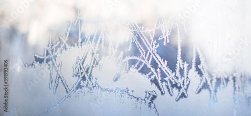 Frost pattern on the window glass. White frost with a blue tinge on a frosty day. Winter, an ornament of nature. Banner, space for text © Ольга Симонова