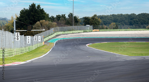 Going towards turn on motorsport circuit asphalt track, boards with number in a row on the left