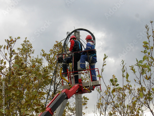 
Electricians on the lift install wires for the power line