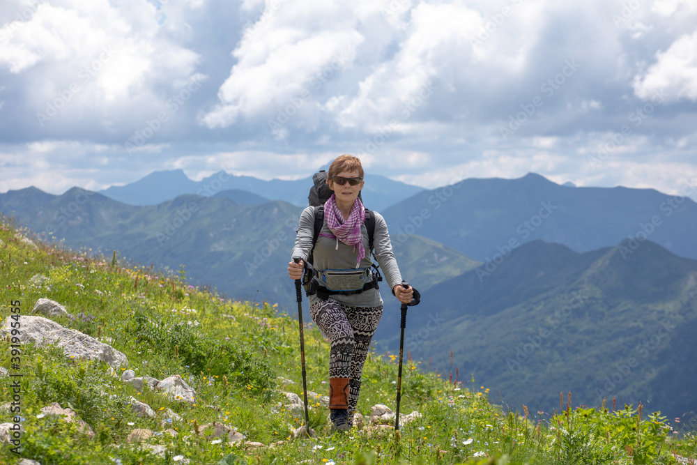 Young woman on a hike overlooking the high mountains