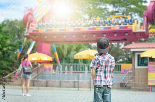 Boy Looks at Pendulum Ride in an Amusement Park.